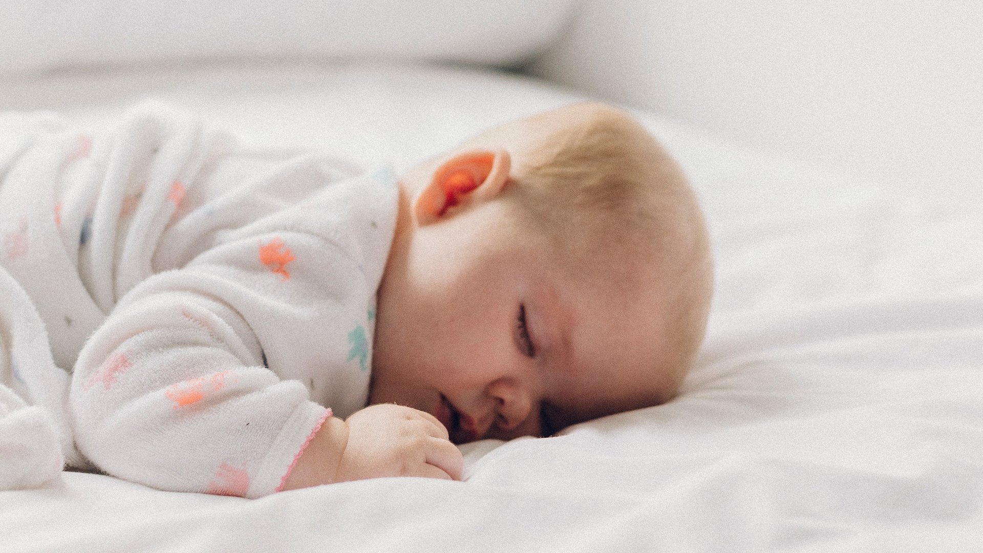 Baby schläft auf einer weißen Decke