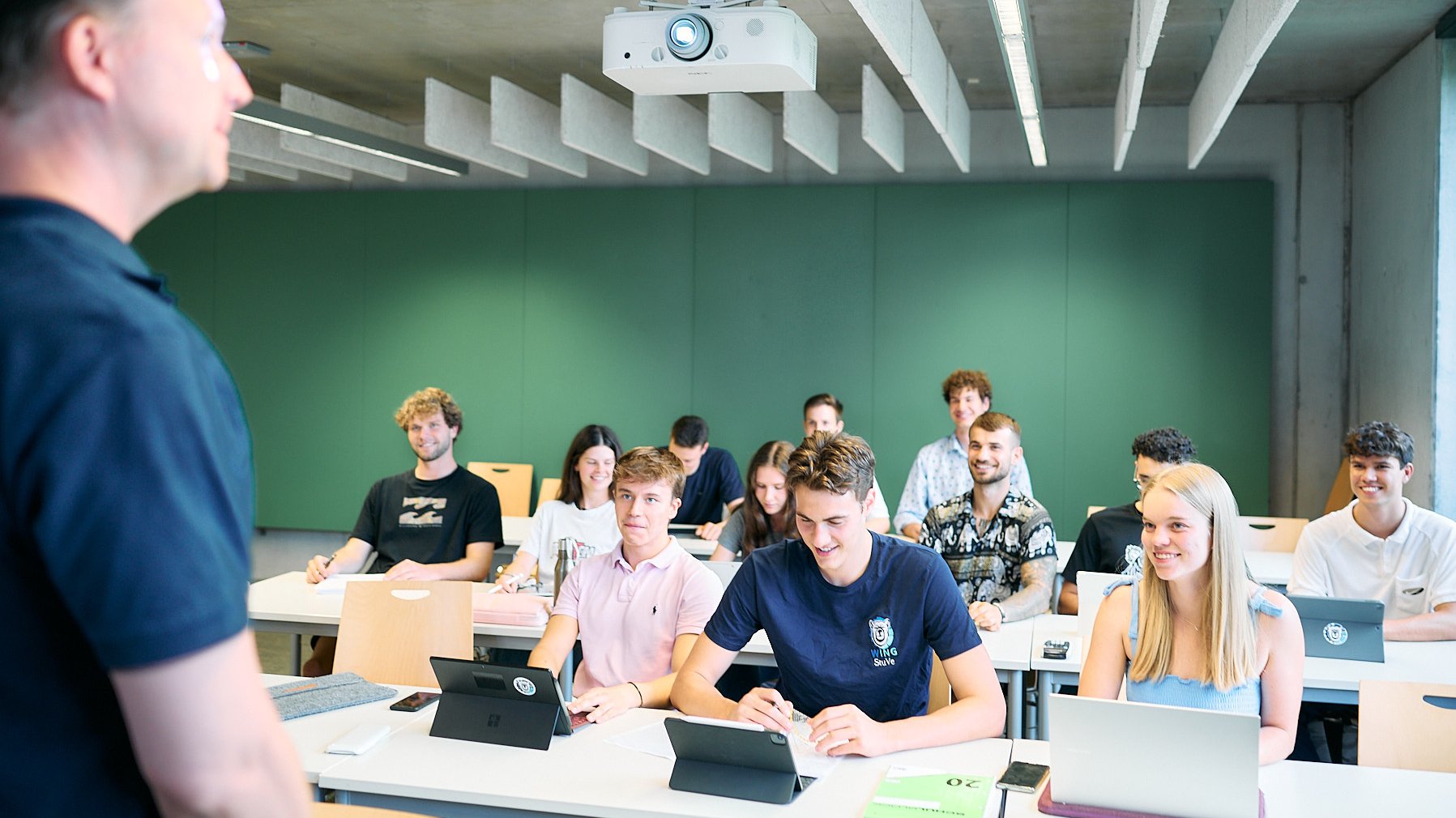 Studierende hören aufmerksam ihrem Professor zu und haben Spaß im Seminar. 