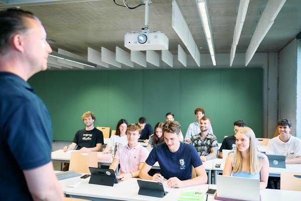 Studierende hören aufmerksam ihrem Professor zu und haben Spaß im Seminar. 