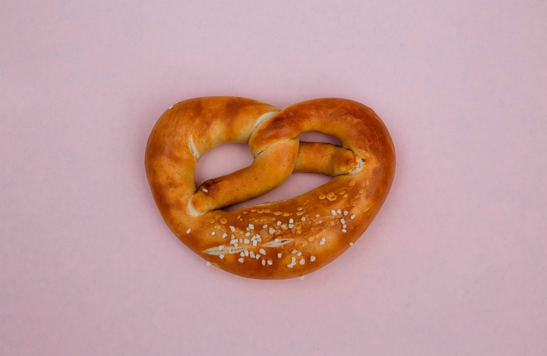 Eine knusprige Brezel auf rosa Hintergrund