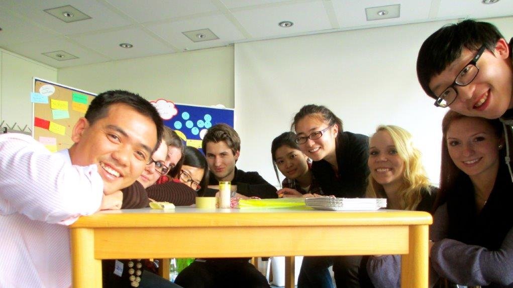 Internationale Studierende posieren während eines Sprachkurses sitzend für ein Foto 