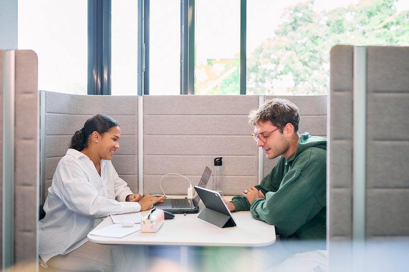 Zwei Studierende lernen gemeinsam in einer Sitzecke